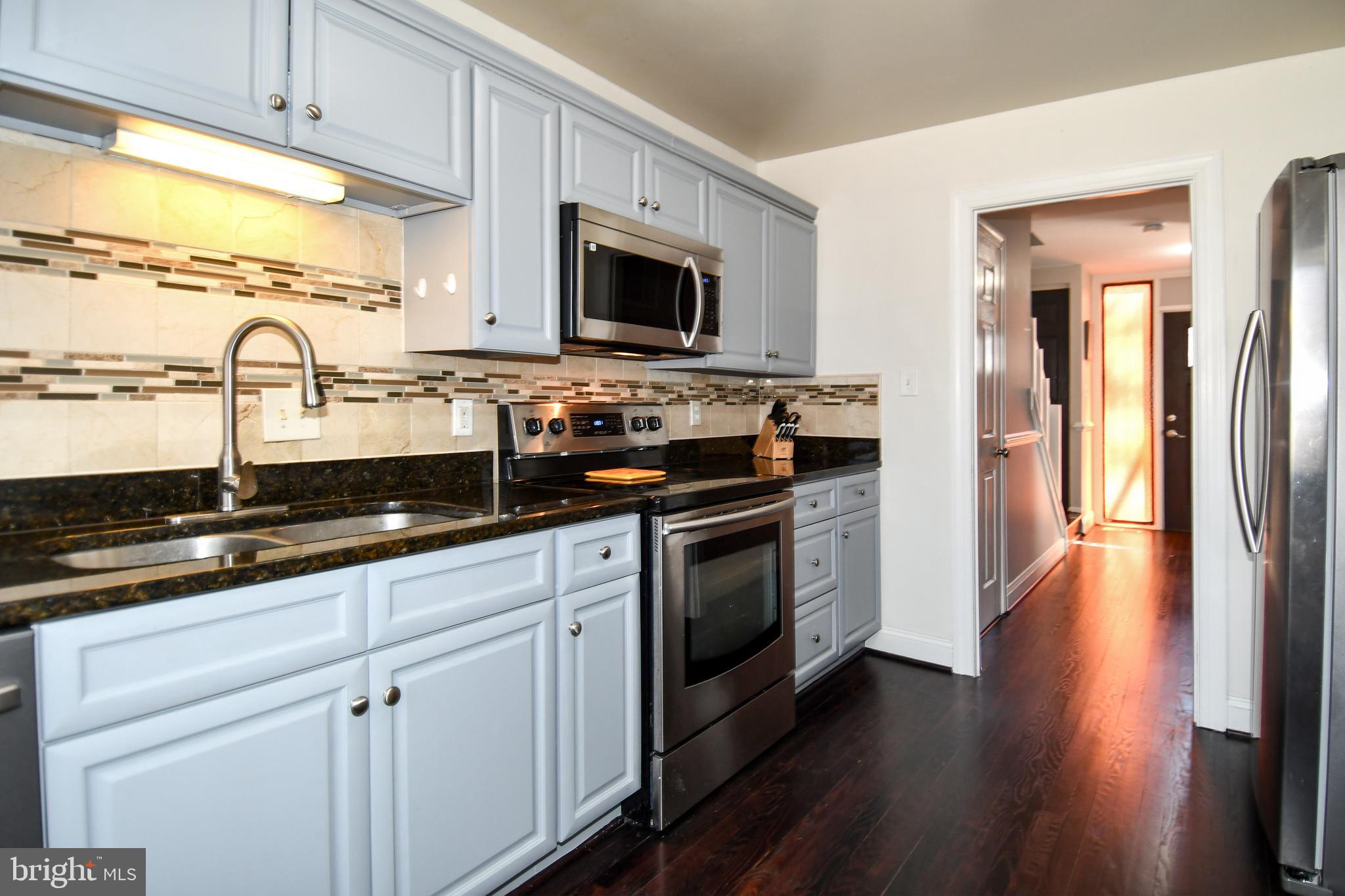 12604 Dulcinea Place Woodbridge, VA 22192 - Photo 25 of 63 a kitchen with stainless steel appliances a stove microwave and sink