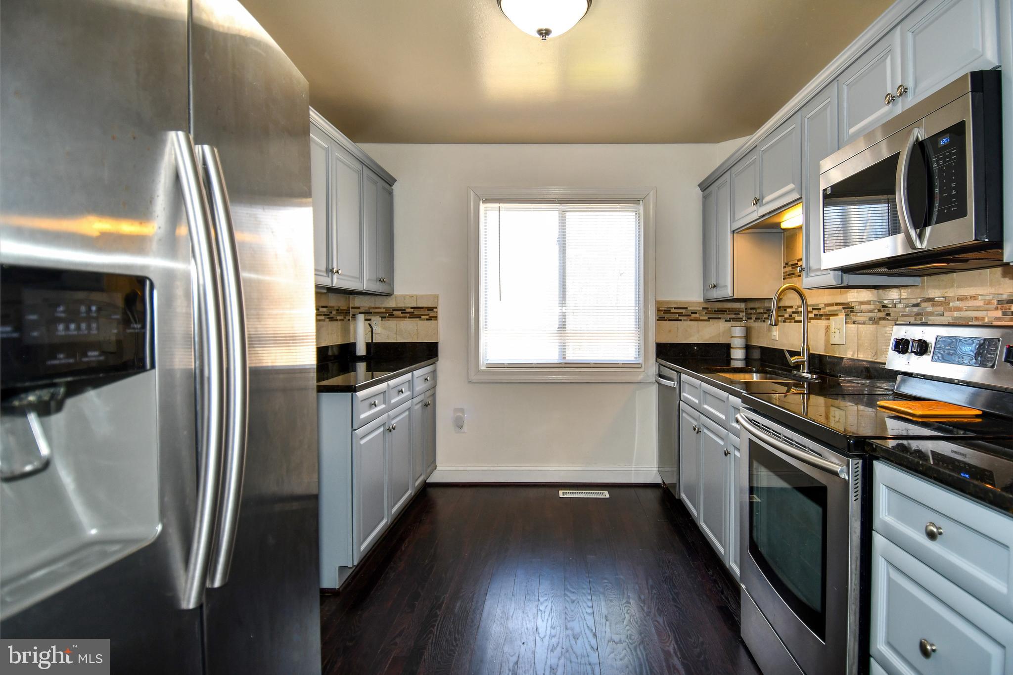 12604 Dulcinea Place Woodbridge, VA 22192 - Photo 27 of 63 a kitchen with stainless steel appliances a refrigerator a sink a stove a microwave and wooden floor