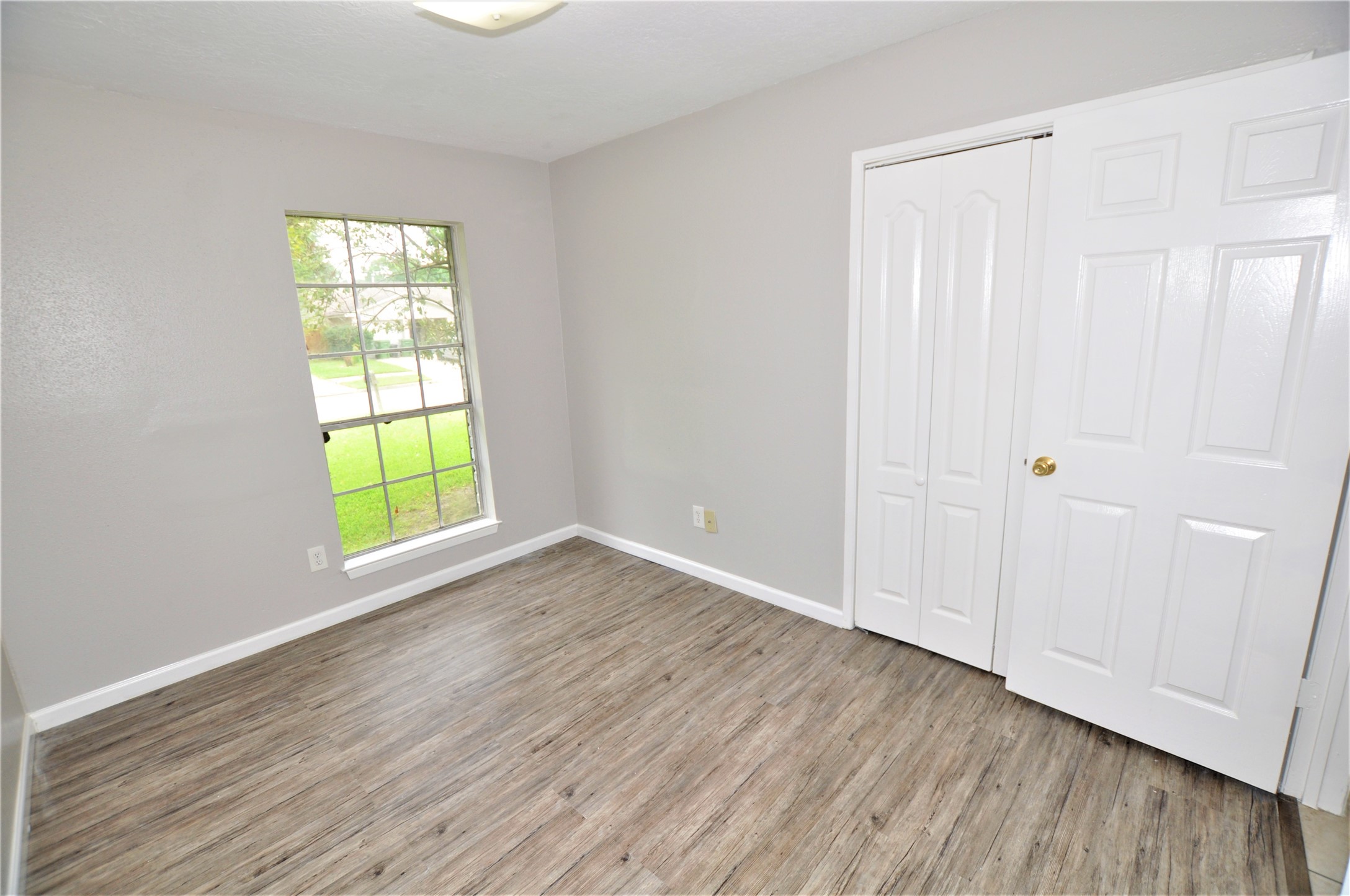 5446 Quail Tree Lane Humble, TX 77346 - Photo 9 of 12 an empty room with wooden floor and windows