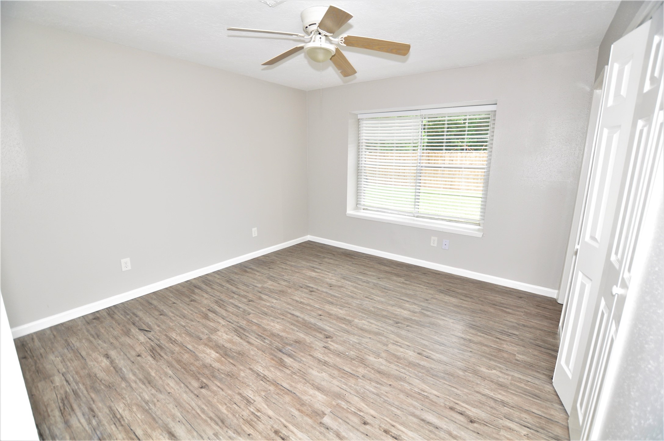 5446 Quail Tree Lane Humble, TX 77346 - Photo 10 of 12 an empty room with wooden floor fan and windows