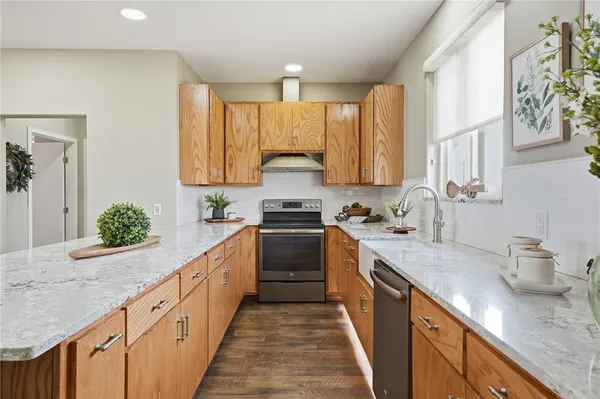 a kitchen with granite countertop a sink stove and cabinets