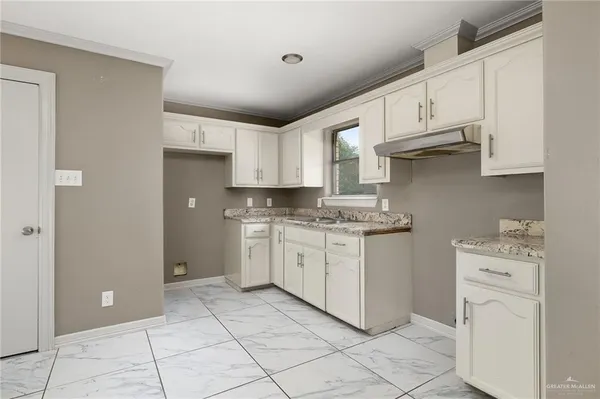 a kitchen with granite countertop cabinets and white appliances