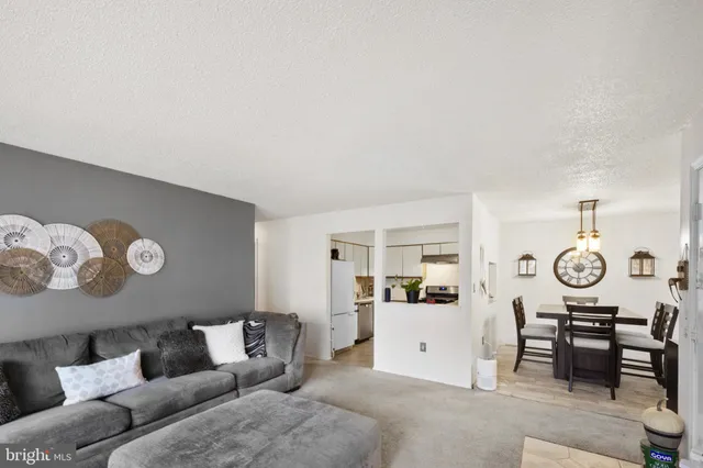 a living room with furniture and kitchen view