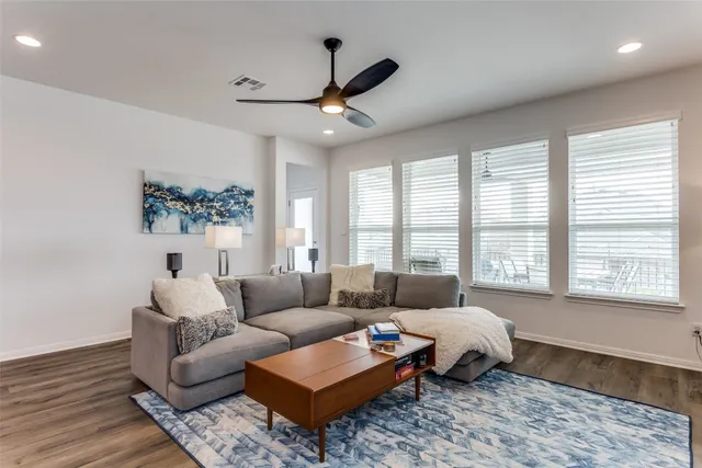 a living room with furniture wooden floor and a large window