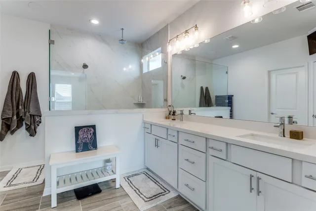 a bathroom with a double vanity sink a mirror and a shower