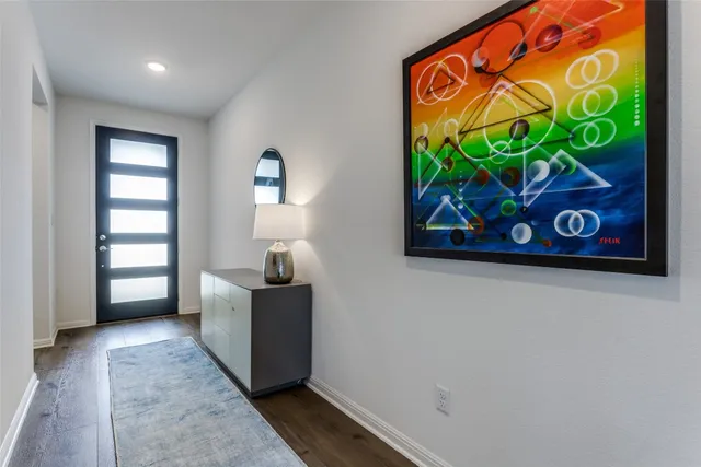 an entryway with wooden floor a painting on the wall and a window