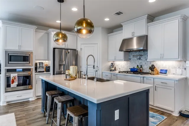 a kitchen with a sink a microwave and cabinets