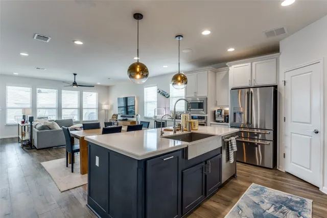 a kitchen with stainless steel appliances granite countertop a sink a stove and a refrigerator