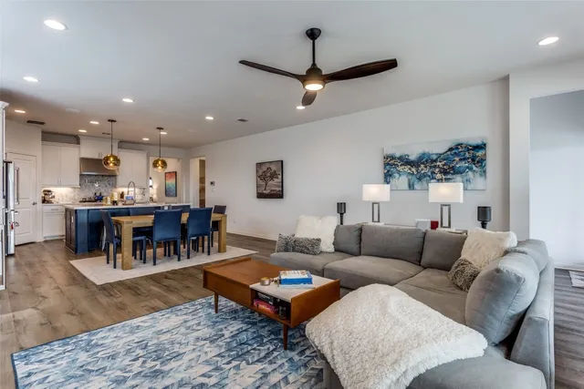 a living room with furniture and a dining table with kitchen view