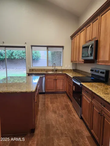 a kitchen with stainless steel appliances granite countertop a stove a sink and a microwave