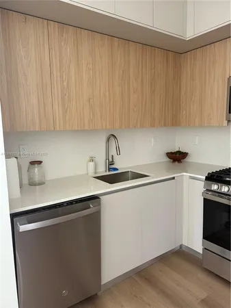 a kitchen with a sink a stove and cabinets