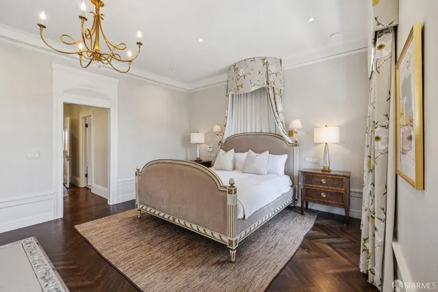 a bedroom with a bed a chandelier and a window