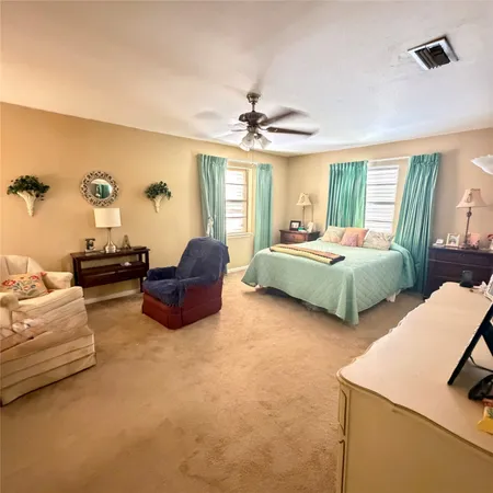 a spacious bedroom with two beds and a chandelier