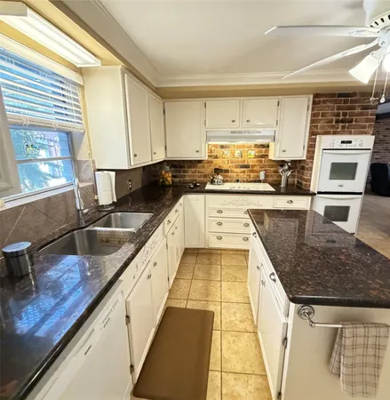 a kitchen with stainless steel appliances granite countertop a sink stove and cabinets