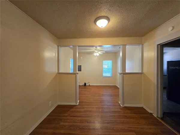 a view of empty room with wooden floor