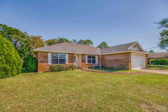 a front view of a house with a yard and trees