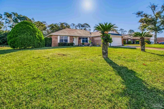 a view of a house with a yard and sitting area