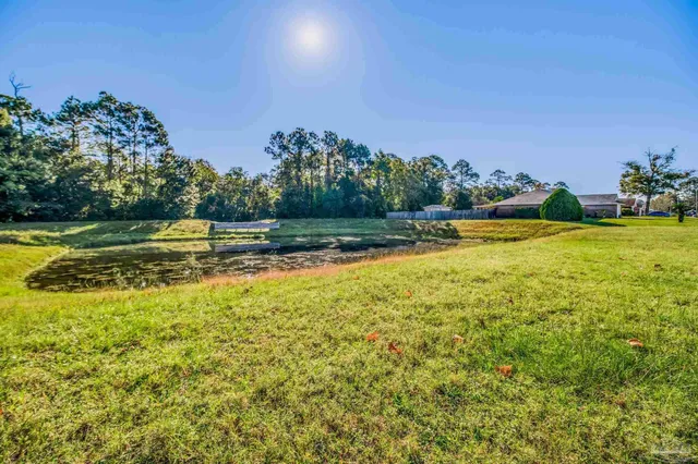 a large kitchen with stainless steel appliances granite countertop a refrigerator a sink dishwasher a stove and a dining table with wooden floor