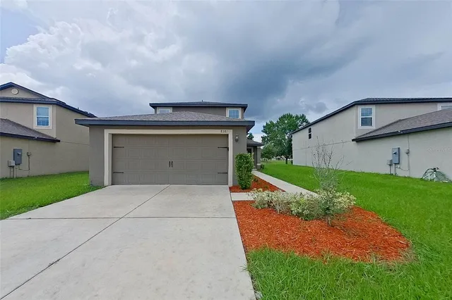 a front view of a house with a yard and garage