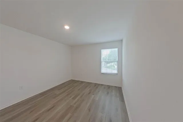 a view of a room with wooden floor and white walls