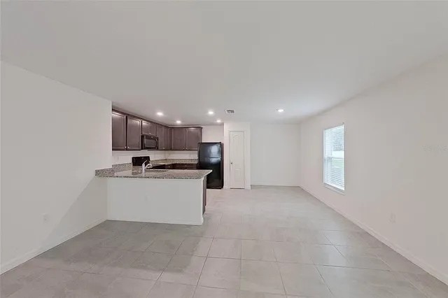 a large white kitchen with kitchen island a sink white cabinets and a fireplace