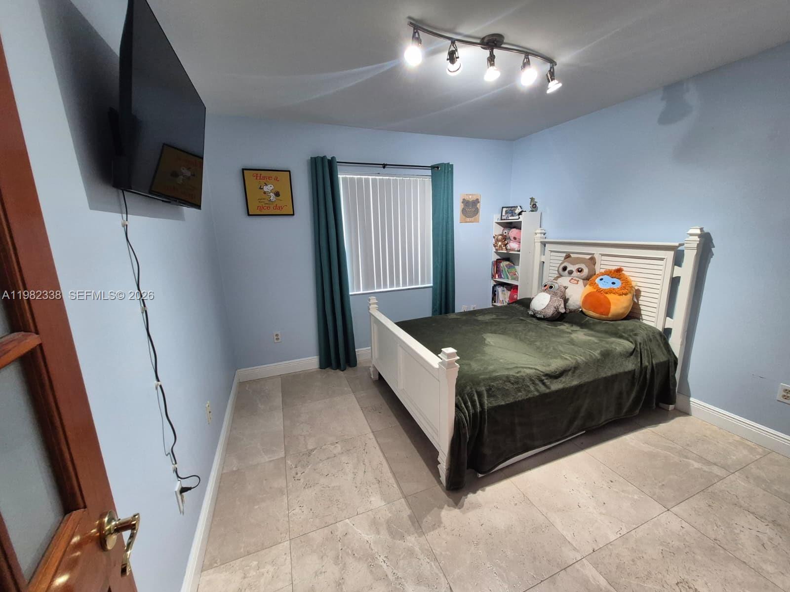 14530 Southwest 110th Street Miami, FL 33186 - Photo 25 of 45 a bedroom with a bed and flat screen tv