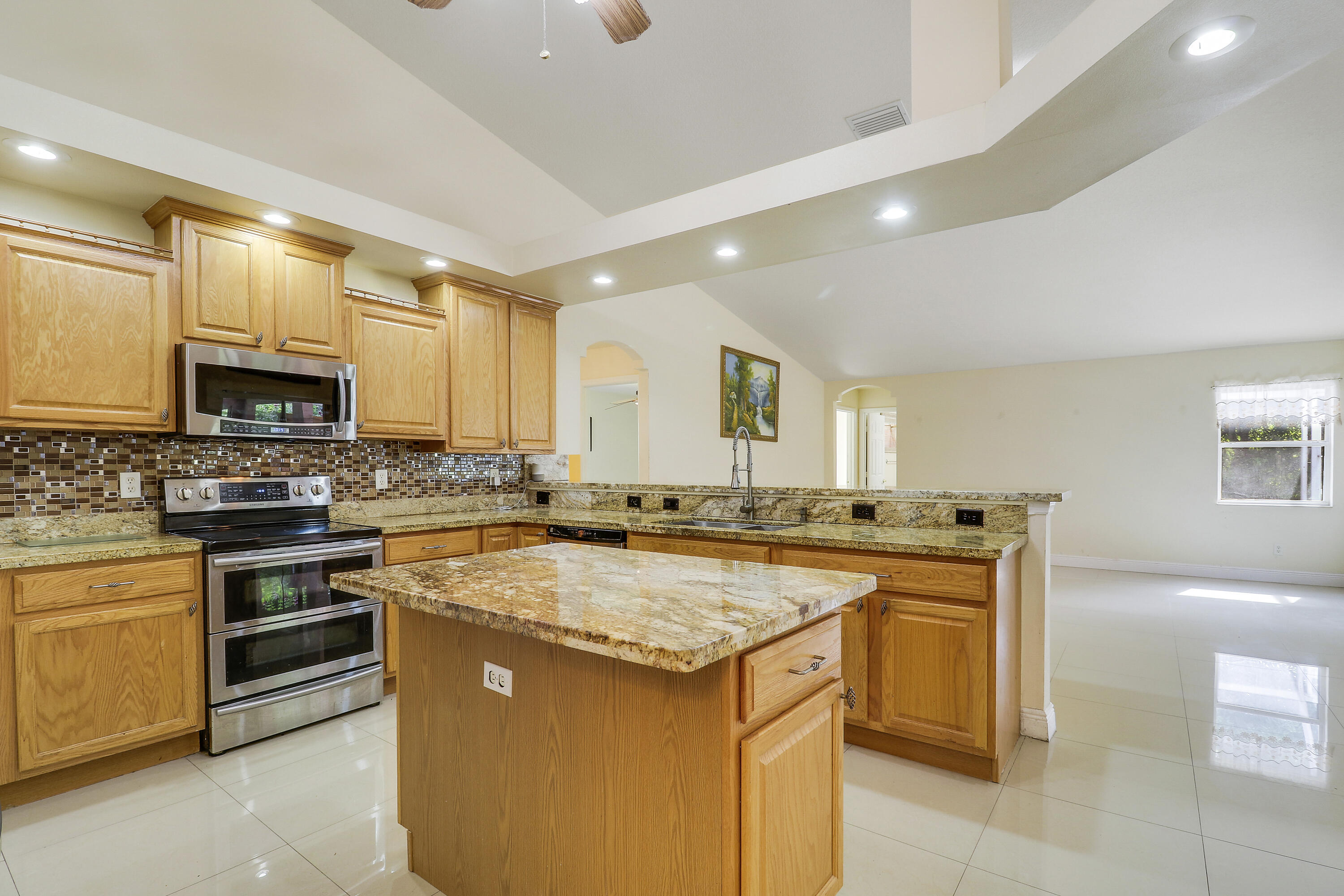 2085 Southwest Aladdin Street Port St. Lucie, FL 34953 - Photo 17 of 45 a kitchen with stainless steel appliances granite countertop a stove sink microwave and cabinets