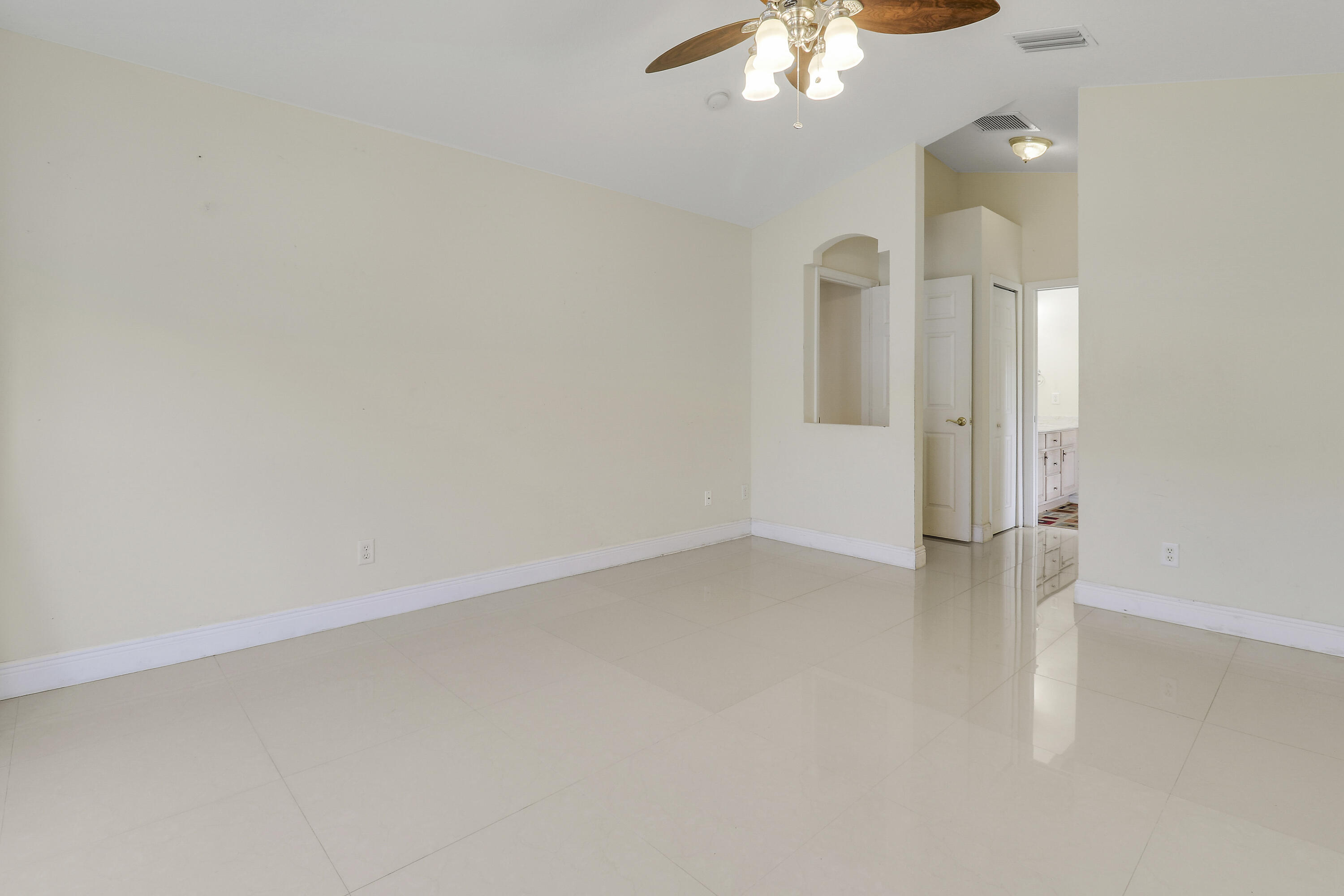 2085 Southwest Aladdin Street Port St. Lucie, FL 34953 - Photo 28 of 45 an empty room with a chandelier fan and kitchen view