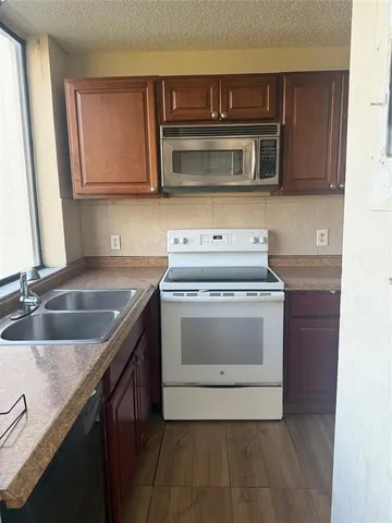 a kitchen with stainless steel appliances granite countertop a sink a stove and a microwave