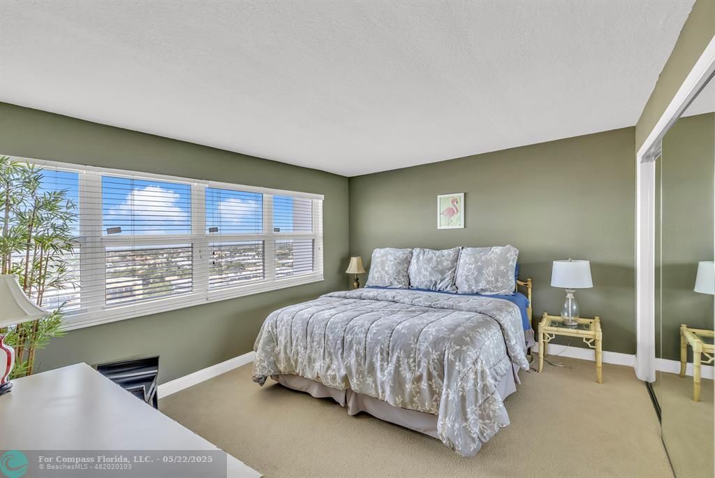 3000 South Ocean Boulevard, Unit 1106 Boca Raton, FL 33432 - Photo 17 of 30 a bedroom with a bed lamp and a large window