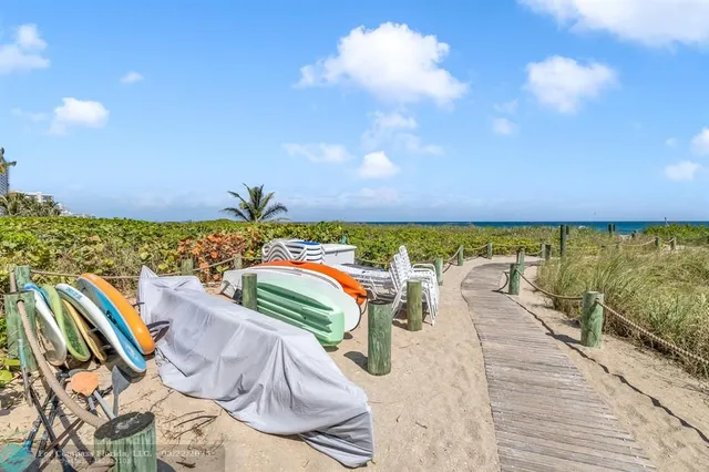 a front view of multi story residential apartment building with yard and green space