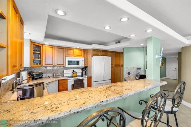 a kitchen with stainless steel appliances granite countertop sink stove and refrigerator