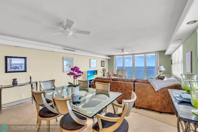 a living room with furniture a chandelier and a dining table