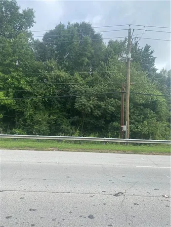 a view of a grassy field with trees in the background