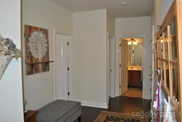 a view of a hallway with wooden floor and bathroom