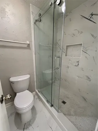 a bathroom with a toilet and a shower