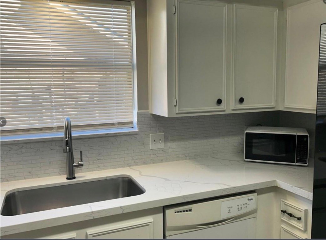 4515 Seneca Street Pasadena, TX 77504 - Photo 6 of 18 a kitchen with a white cabinets and a microwave oven