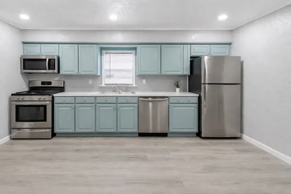 a kitchen with stainless steel appliances granite countertop a stove a sink and a refrigerator