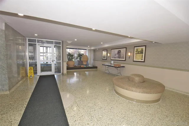 a view of a hallway with furniture and a large window