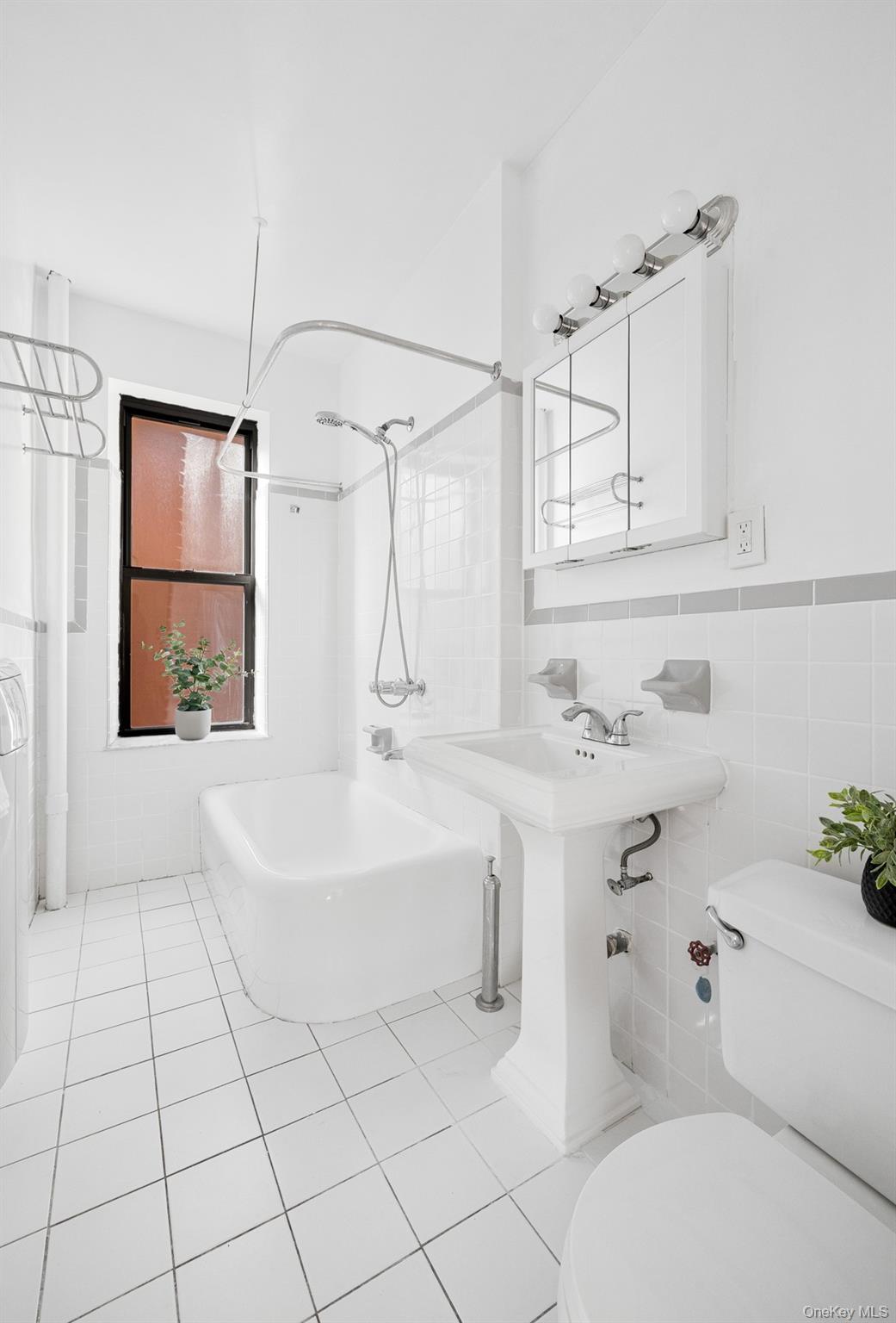 41-42 42nd Street, Unit E4 Queens, NY 11104 - Photo 12 of 17 a bathroom with a sink toilet vanity and shower