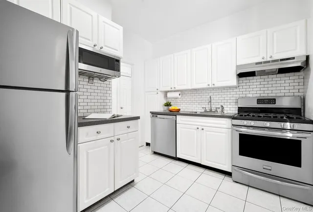 a kitchen with granite countertop white cabinets and white appliances