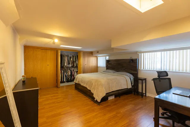 a bedroom with a bed and wooden floor