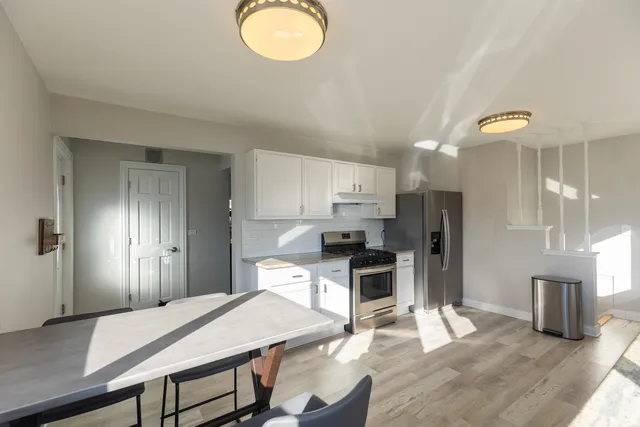 a kitchen with stainless steel appliances kitchen island granite countertop a refrigerator a stove top oven and a sink