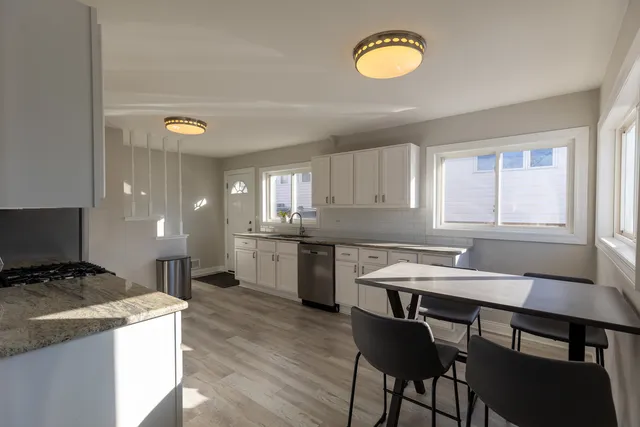 a kitchen with a stove a sink cabinets and a dining table