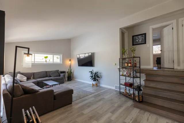 a living room with furniture and a wooden floor