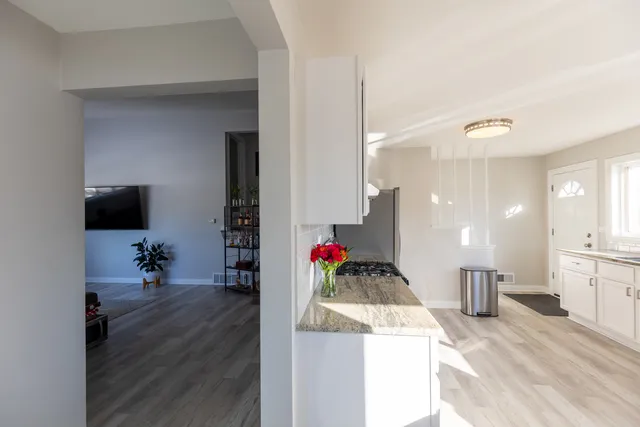 a living room with kitchen island granite countertop furniture and a wooden floor