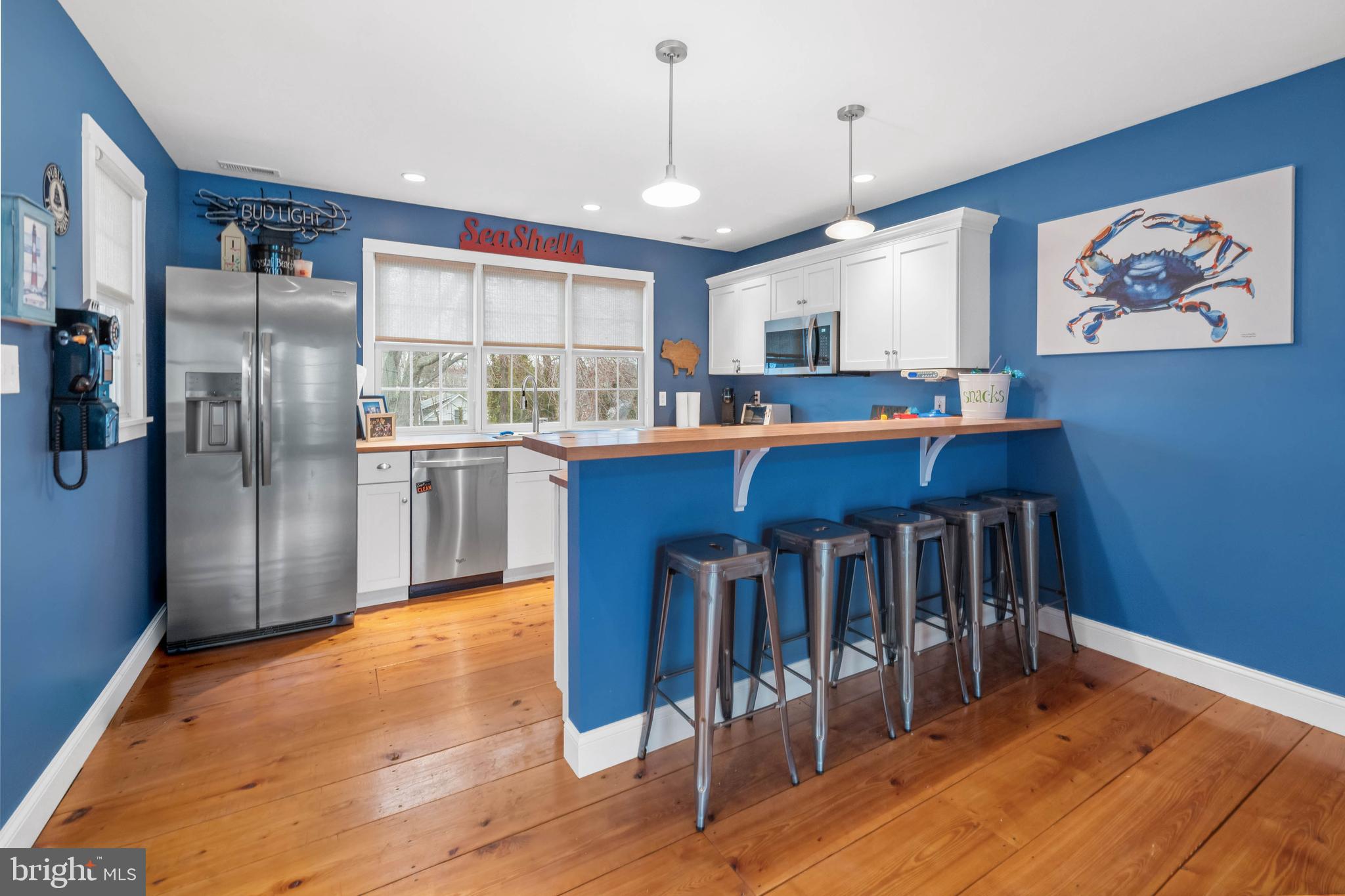 38 Virginia Avenue Earleville, MD 21919 - Photo 35 of 60 a kitchen with stainless steel appliances granite countertop a refrigerator a sink dishwasher a stove and a dining table with wooden floor