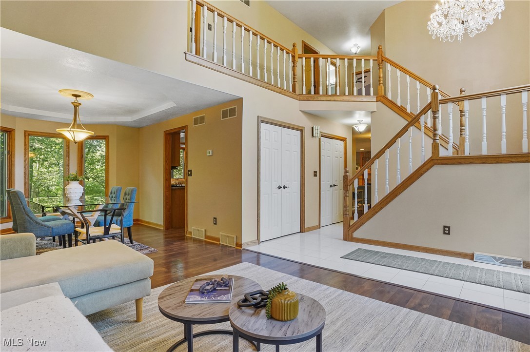 370 Wilcox Road Youngstown, OH 44515 - Photo 4 of 49 Living area featuring wood finished floors, stairway, a high ceiling, and a chandelier