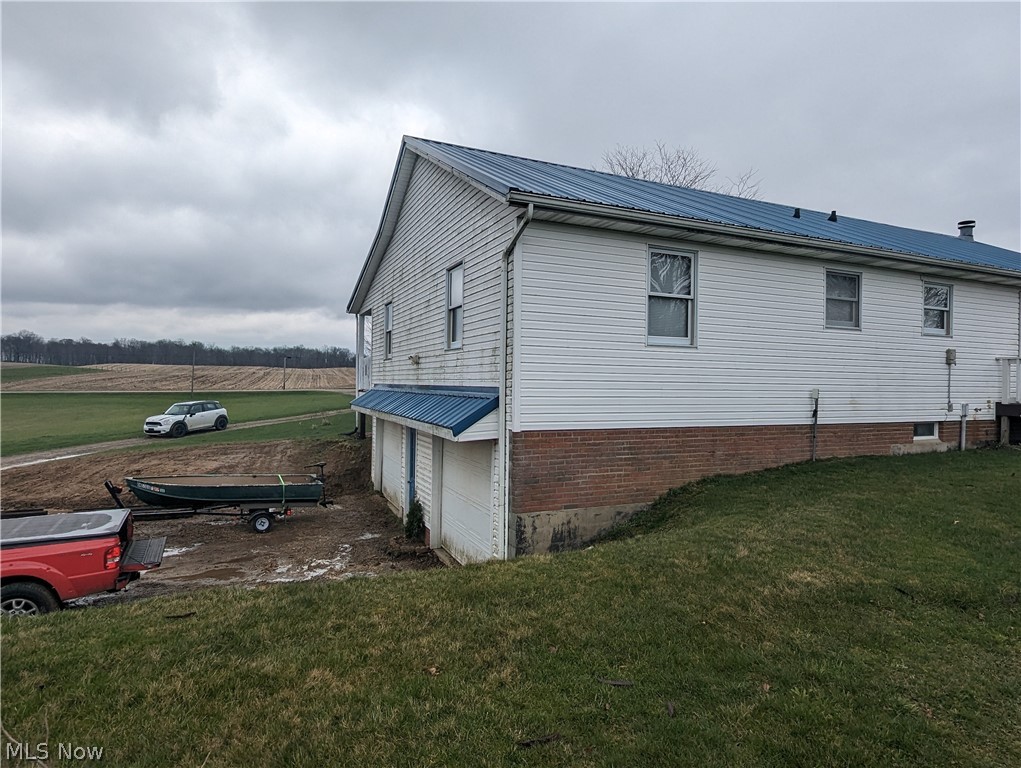 6333 Rochester Road East Rochester, OH 44625 - Photo 10 of 47 View of side of home featuring a lawn and a garage