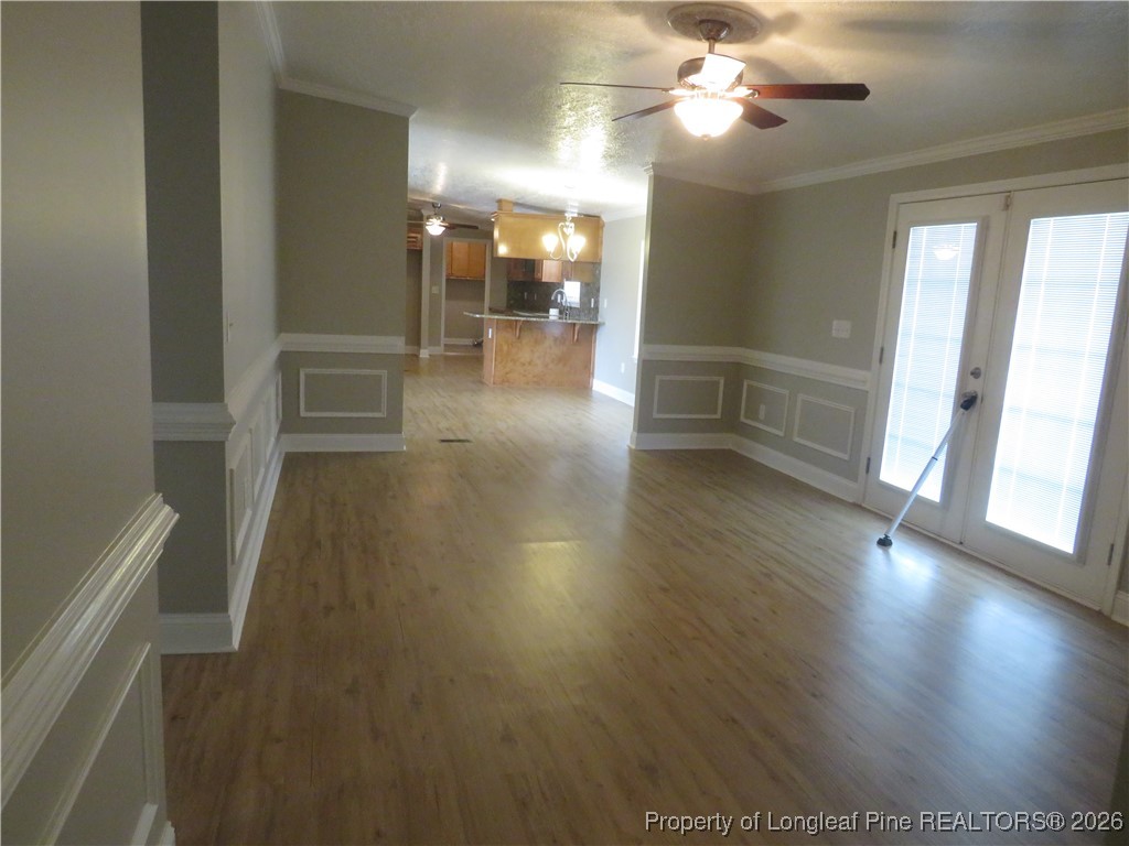 1184 Fisher Road St. Pauls, NC 28384 - Photo 20 of 29 a view of a hallway with wooden floor and a kitchen space